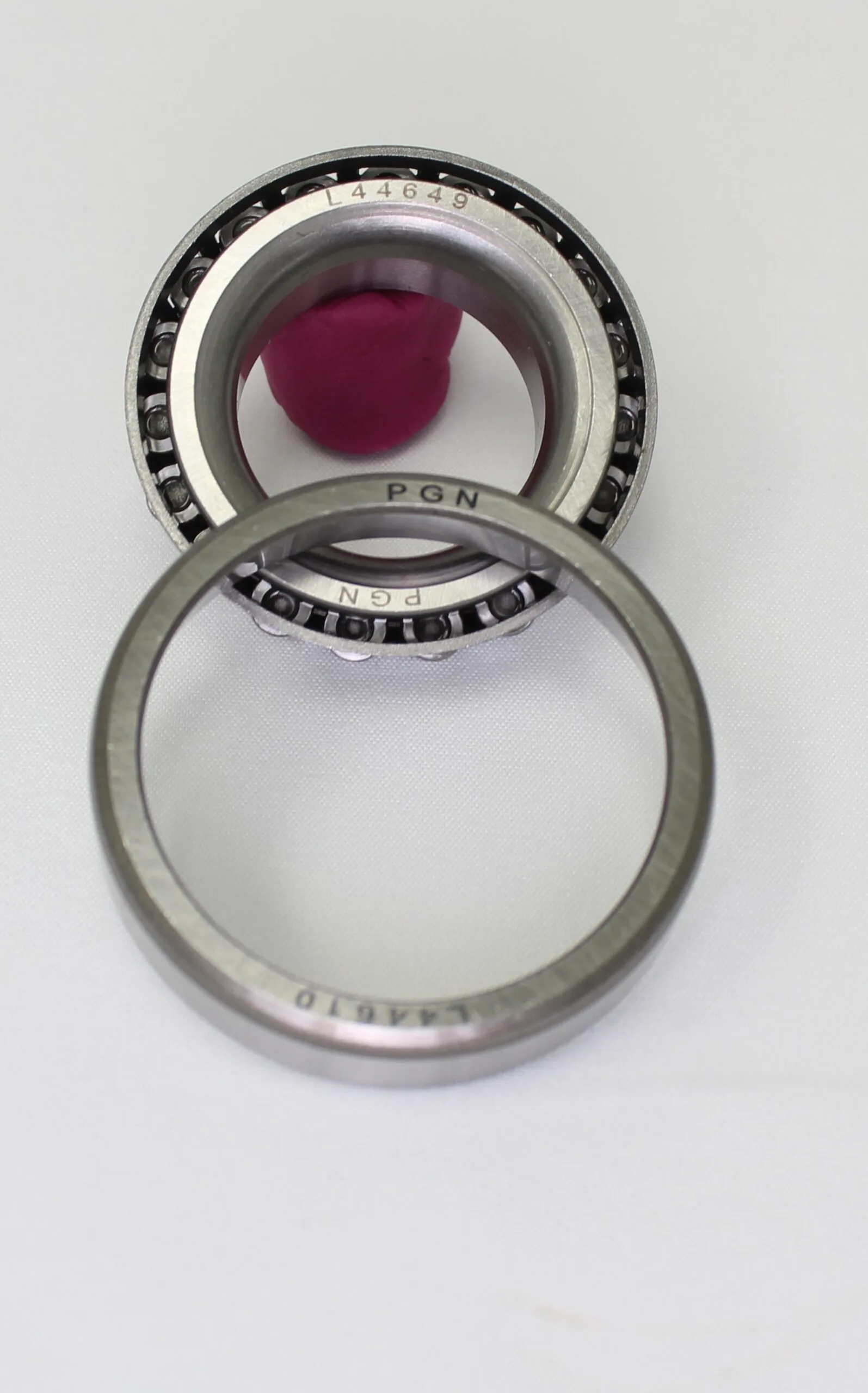 Detailed close-up of a PGN tapered roller bearing cone and cup on a white background.