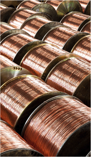 Rows of large industrial spools filled with copper-colored welding wire.