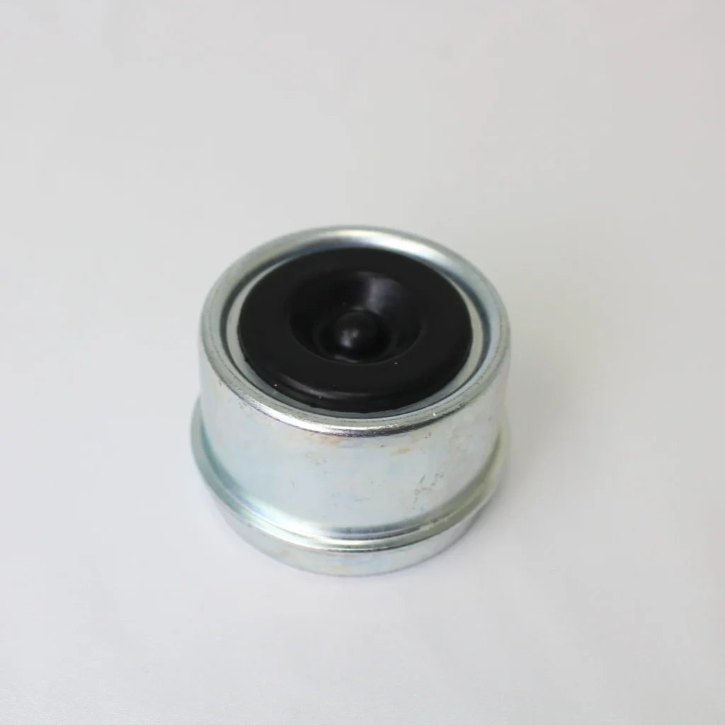 Metal grease cap with a black rubber center plug on a white background.