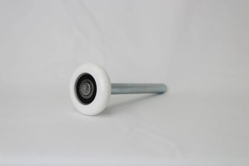 White nylon roller with a metal shaft displayed on a white background.
