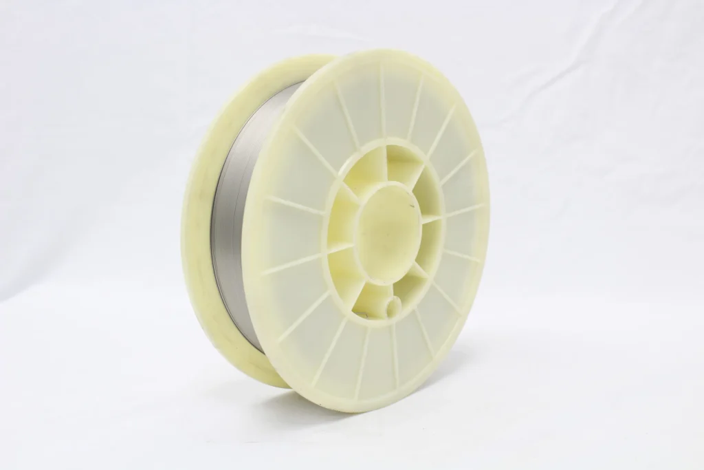 Industrial plastic spool with metal wire wound around it on a white background.