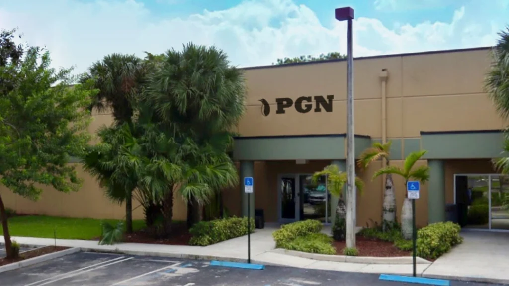 Exterior entrance of PGN Bearings facility with parking area and palm trees.