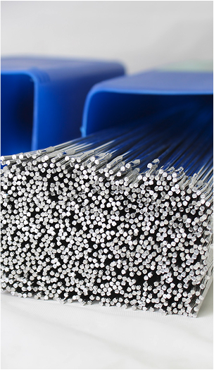 Close-up of bundled TIG welding filler rods inside blue plastic containers.